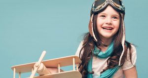 Smiling girl holding a toy airplane