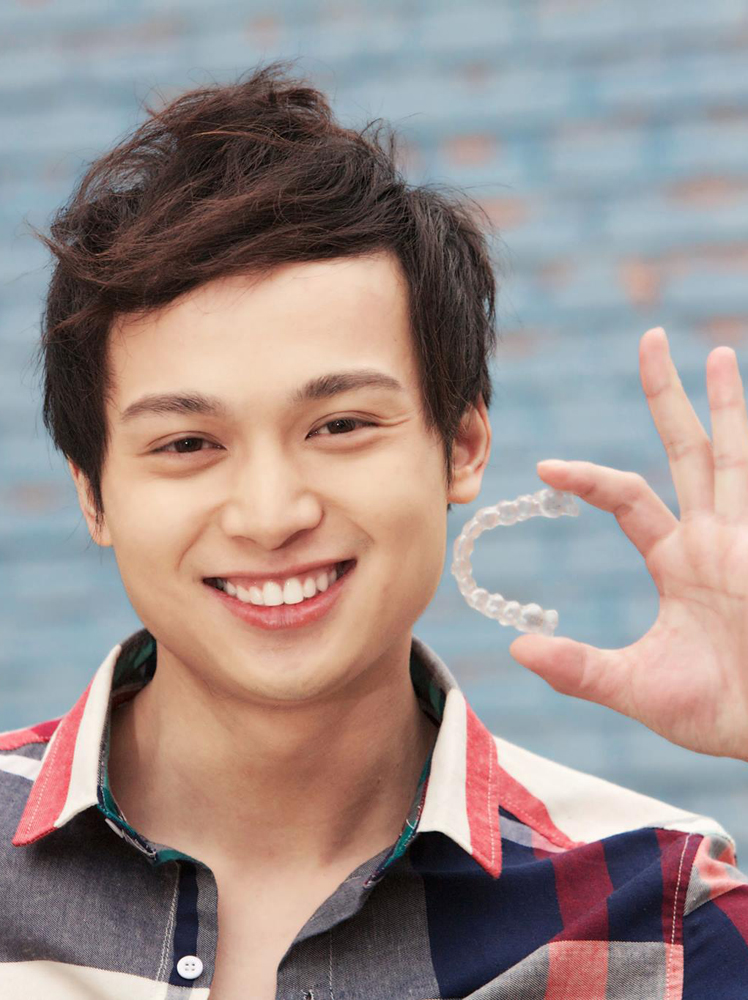 Boy-smiling-holding-Invisalign-tray-in-brooklyn