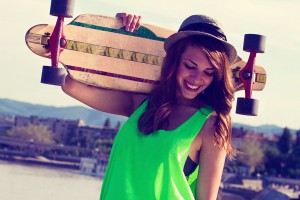 teen smiling holding skateboard