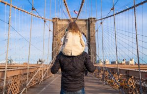 Girl on father's shoulder on Brooklyn Bridge