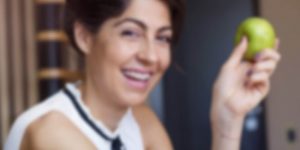 woman with braces holding apple