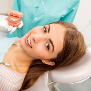 woman with clear braces on dental chair