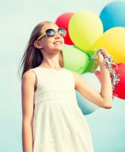 girl wearing sunglasses holding colorful ballons