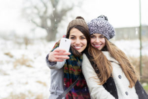 two teens taking selfie in winter