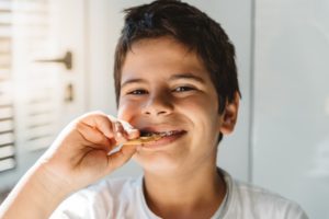 Kid eating a cookie with braces.
