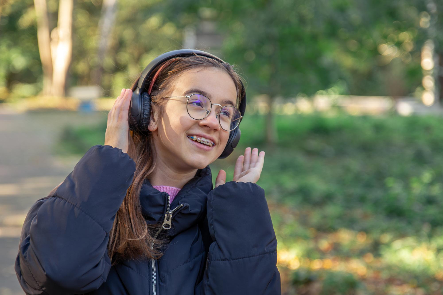 A girl with braces and headphones for a blog post on summer camp tips for orthodontic patients