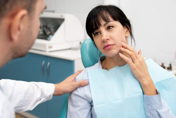 A woman showing her jaw misalignment to an orthodontist